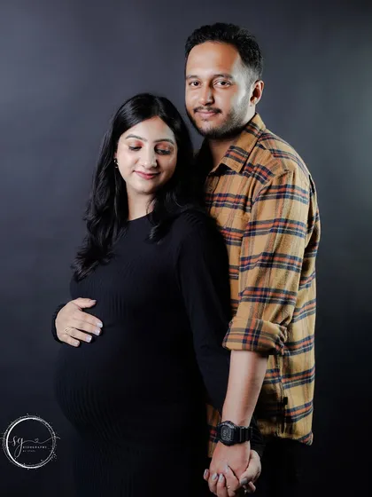 A simple, elegant portrait of an expecting couple holding hands. This pose emphasizes their unity and shared path forward as they prepare to become parents.