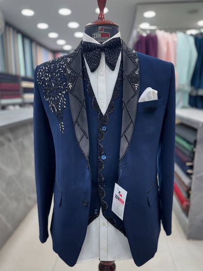 A full view of the navy blue tuxedo, showcasing the detailed waistcoat and the crisp white pocket square. This is a complete, ready-to-wear look for any reception.