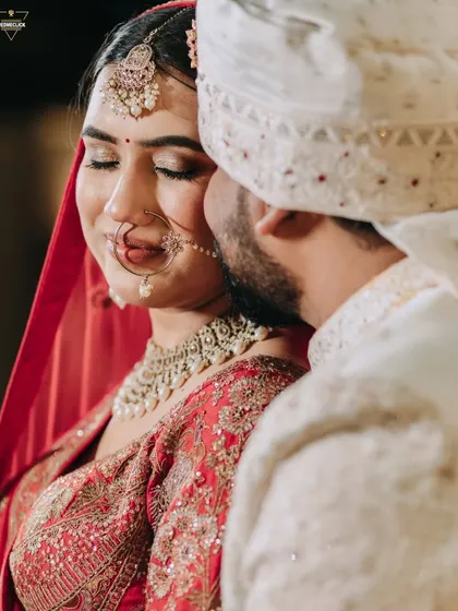 An intimate and tender moment between the bride and groom. The soft lighting and their gentle expressions create a feeling of serene love amidst the wedding day excitement.
