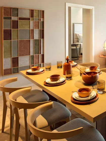 A dining table set for a meal, illustrating how we design spaces for living. The warm wood table, comfortable chairs, and geometric art piece create an inviting atmosphere for sharing food and making memories.