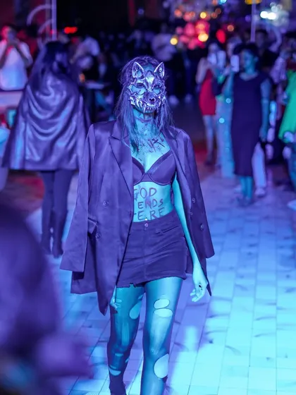 A model walking the runway in a terrifyingly cool wolf mask at the Halloween fashion show.
