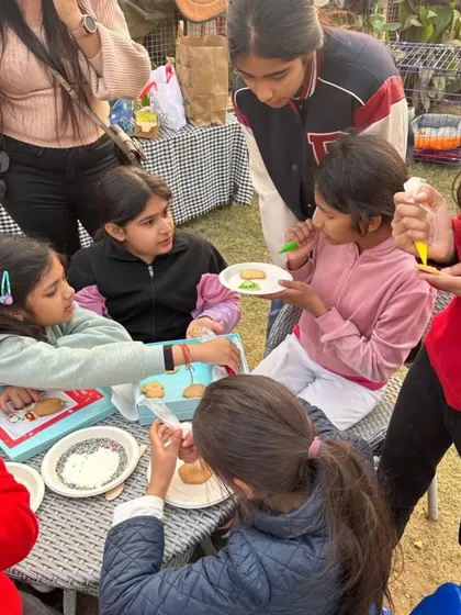 Children gathered around a table, focused on decorating Christmas cookies, one of the fun activities I organize for holiday events.
