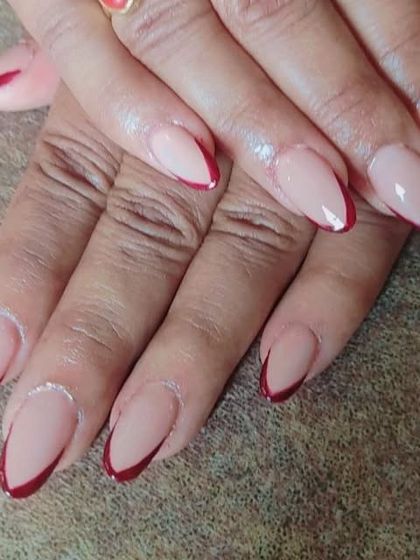 An elegant and sharp V-shaped French manicure using a deep maroon color on almond-shaped nails for a sophisticated look.