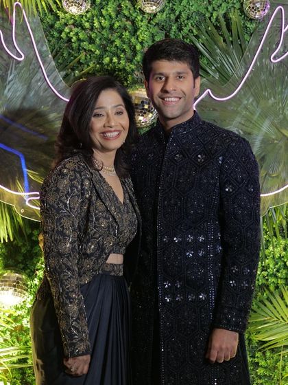 The mother of the groom with her son, both looking elegant and happy.