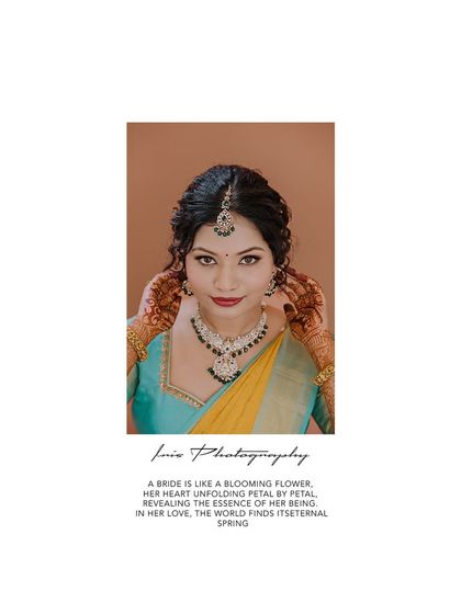 A direct and captivating bridal portrait. The bride's hands framing her face draw attention to her expression and the intricate mehndi.