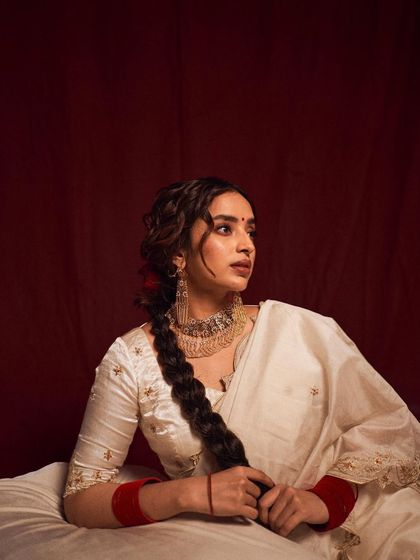 A serene and classic portrait. The model's thoughtful expression and the traditional styling evoke a sense of calm and timeless elegance, reminiscent of vintage Indian portraiture.