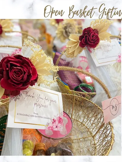 A beautiful open basket return favour for a housewarming, but perfect for a wedding too. The gold wire basket is adorned with a red rose and filled with traditional items.