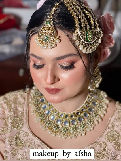 A beautiful Nikkah look in a soft pink outfit. The makeup is kept subtle and elegant, with a focus on her eyes.