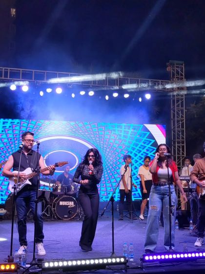 The full band in action at The Galleria Mall. This shot shows our complete lineup, from guitars and drums to backing vocalists, all contributing to a powerful live sound.