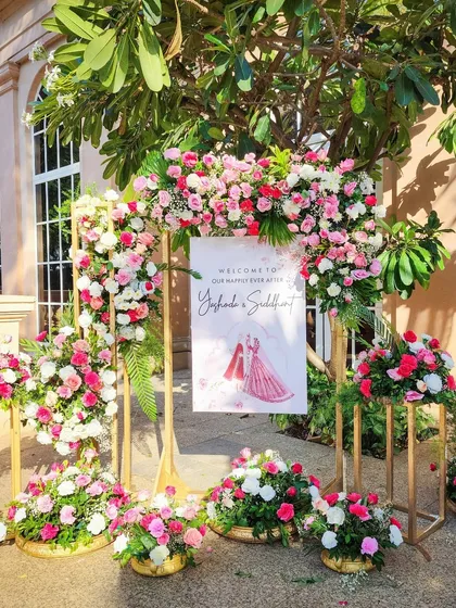 A personalized welcome sign for the couple, framed by an arrangement of pink and white flowers, sets a personal and romantic tone.