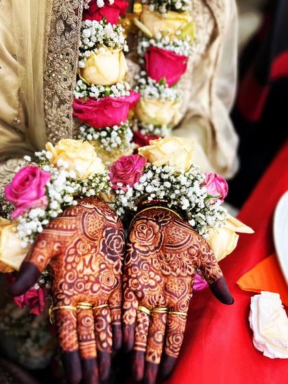 A beautiful engagement ceremony look, with the couple's initials 'MM' and interlocking rings drawn on the palms.