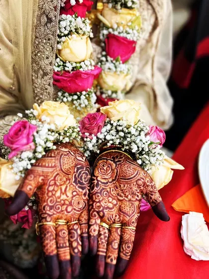 A beautiful engagement ceremony look, with the couple's initials 'MM' and interlocking rings drawn on the palms.