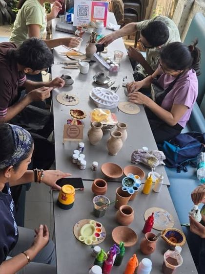 An overhead view of a busy painting table. You can see the variety of pots and paints available, showing the endless creative possibilities.