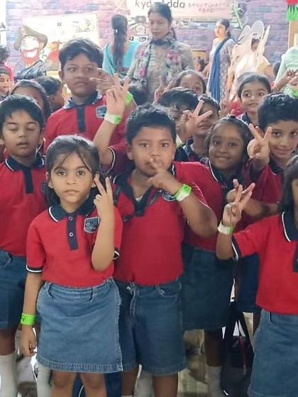 Peace signs and happy faces all around! This group of students is all smiles during their field trip, showing off the fun they're having at our play center.