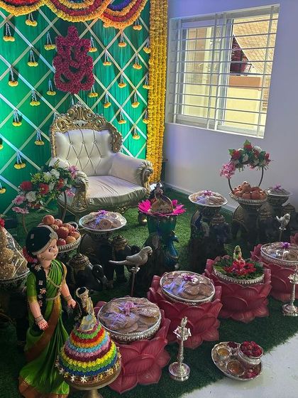 A side view of the home ceremony decor, showing the arrangement of props and offerings on an artificial grass carpet.