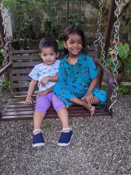 Cousins having fun on a swing set. The girl on the right is wearing one of our Christmas print pyjama sets, showing how easy it is to move and play in them.