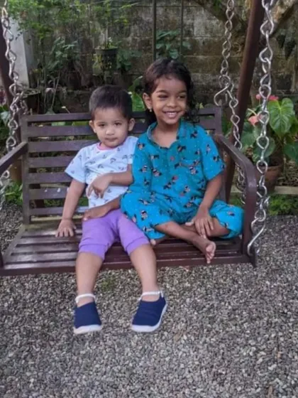 Cousins having fun on a swing set. The girl on the right is wearing one of our Christmas print pyjama sets, showing how easy it is to move and play in them.
