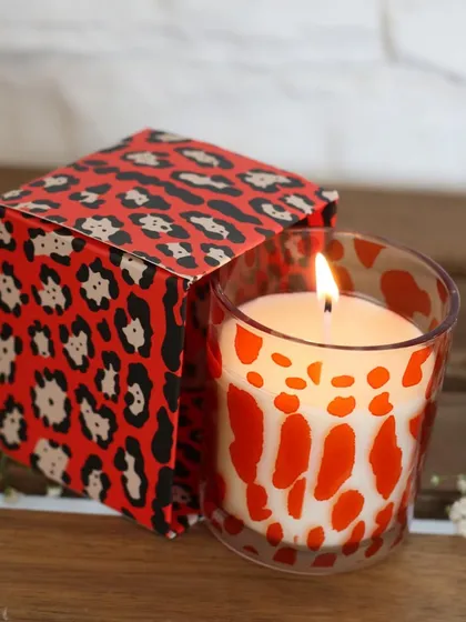 A bold, red leopard-print scented candle. This piece is for those who love to make a statement, combining a wild pattern with a soothing fragrance for a unique sensory experience.