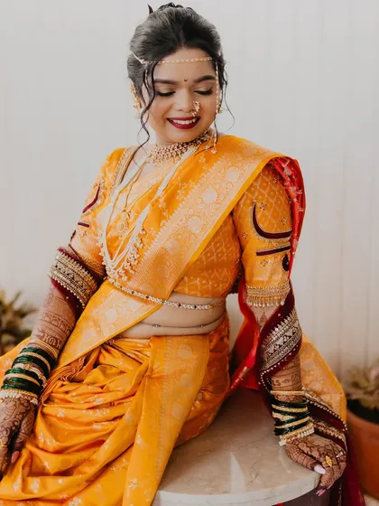 A seated portrait of the bride, showcasing the full elegance of her Nauvari saree.