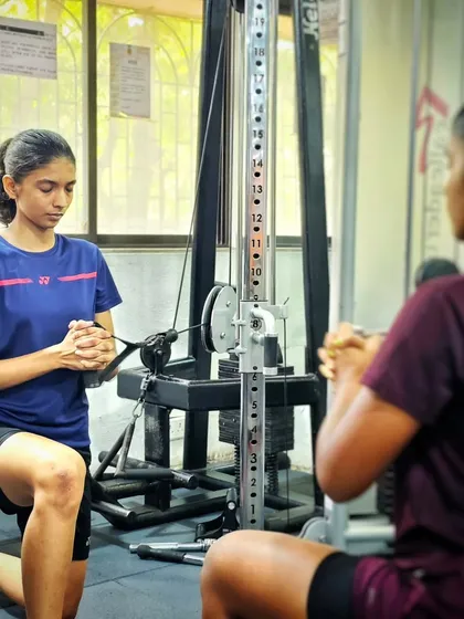 A player focuses on her form during a cable machine exercise, building core strength and rotational power.