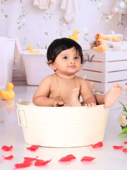 This little one is having a great time during a splash session, surrounded by bubbles and rubber ducks. The pure joy on his face is what makes these photos so special.