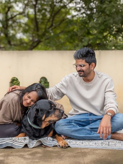 A beautiful, relaxed family portrait with Jag the Rottweiler on the terrace of their home. The natural setting adds to the authentic feel.