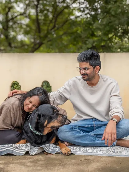 A beautiful, relaxed family portrait with Jag the Rottweiler on the terrace of their home. The natural setting adds to the authentic feel.
