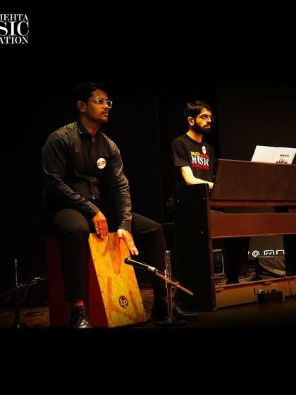 Two of our students perform on stage with their teacher. We provide a complete support system, including professional accompaniment, to ensure our students shine during their performances.