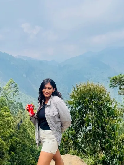 A traveler enjoying the breathtaking views of the Kodaikanal hills on a clear day.