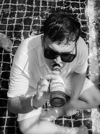 A candid black and white shot of a guest relaxing in the pool, capturing the casual and fun atmosphere.