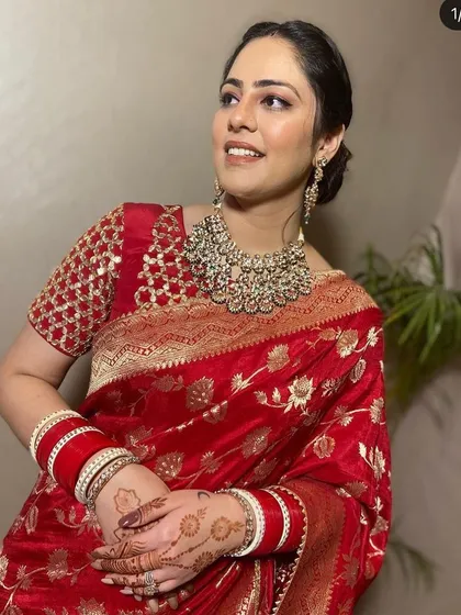 A timeless look for any festive occasion. This client is radiant in a classic red Banarasi silk saree, paired with a heavy rental Polki necklace that elevates the entire outfit.