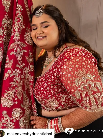 A beautiful, candid moment of the bride with her wedding lehenga. Her soft, glowing makeup ensures she looks radiant even in her quiet, unposed moments.