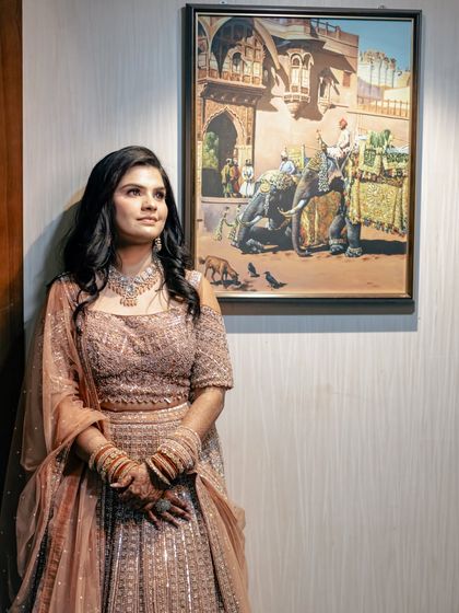 A thoughtful portrait of the bride in a beautiful pastel lehenga. The soft lighting and artistic background create a feeling of serene elegance.