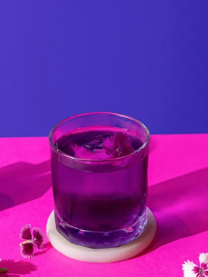 A deep purple cocktail against a vibrant pink and purple background. This minimalist, colour-blocked style is modern, bold, and perfect for a trendy bar menu.