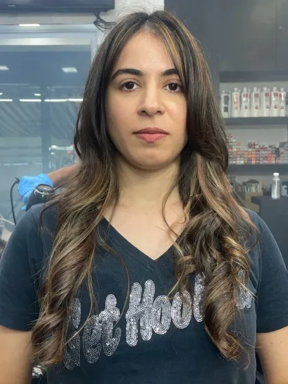 This client is confidently showing off her new face-framing layers and soft waves. It's a versatile style that looks great from every angle.