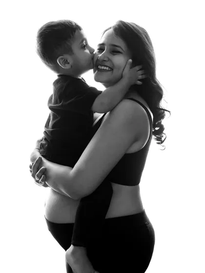 A big kiss for mom! This high-contrast black and white photo is so full of love and joy. Capturing the bond between a mother and her child before a new sibling arrives is always so special.