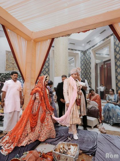 A shot of the couple during the Pheras ceremony, with the bride's long veil trailing behind her, adding a touch of grace and tradition to the moment.