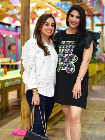 Moms deserve to have fun too. Two mothers take a moment to pose for a photo and enjoy the celebration.