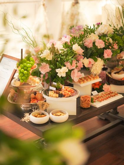 Another perspective of our elegant grazing table, highlighting the careful placement of each element, from bowls of olives and crackers to platters of goat cheese crostinis. Every detail is considered to ensure a beautiful presentation.