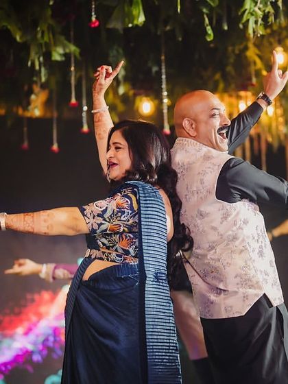 A fun, back-to-back pose by the bride's parents during their sangeet performance. This captures the playful and loving spirit of their dance.