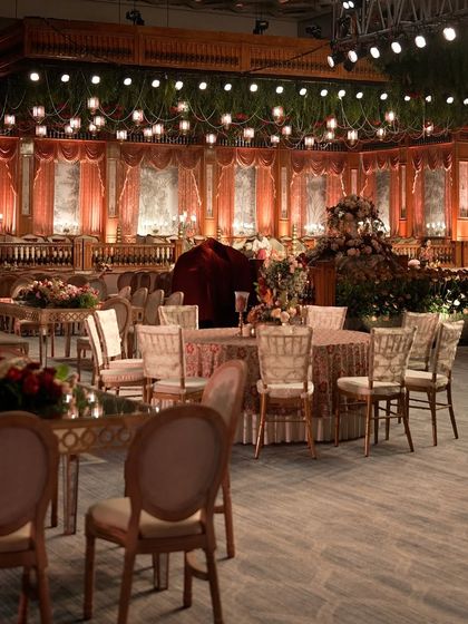 A glimpse into a grand, theatrical reception at the Jio World Convention Centre. The design featured rich fabrics, intricate architectural details, and moody lighting to create an atmosphere of regal opulence.