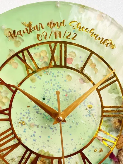 A detailed shot of the top of the clock, showing the custom inscription of the couple's names and their wedding date.