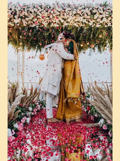 A hug of pure joy and relief under a shower of petals. Nikita and Shriyansh celebrate the conclusion of their beautiful wedding ceremony.