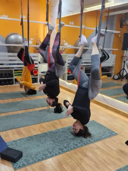 Flipping your perspective is one of the best parts of aerial yoga. This group inversion pose isn't just a cool photo opportunity; it's a form of aerial inversion therapy that helps decompress the spine, improve circulation, and gives you a natural rush of energy.