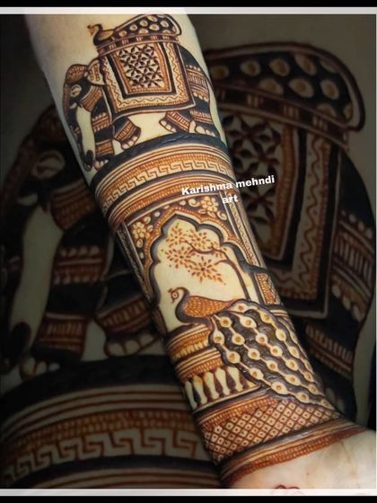 A close-up of an arm adorned with classic Rajasthani motifs. This design features a decorated elephant and a peacock perched by a tree, showcasing detailed and bold traditional artwork.