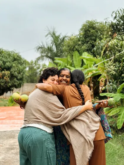 A heartfelt hug between students and a local woman from our community. The connections we make here extend beyond the ashram walls, rooted in love and gratitude.