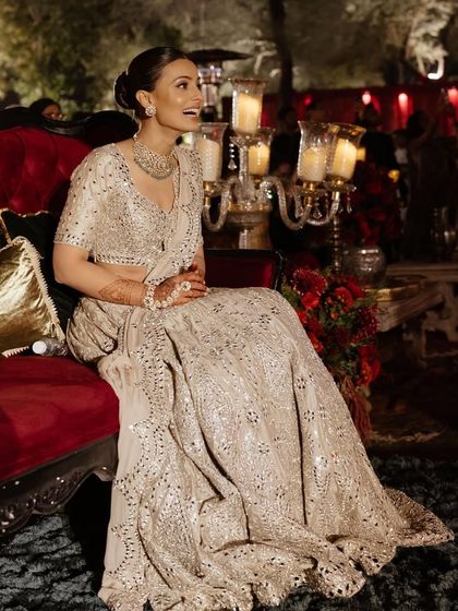 The bride enjoying the Sangeet night from a beautiful velvet couch.
