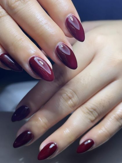 A perfectly shaped set of deep maroon nails. The high-gloss finish makes the color look incredibly rich and luxurious.
