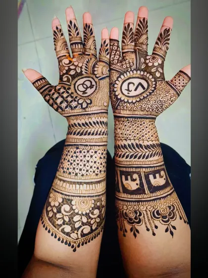 The full view of the engagement mehandi, extending up the forearms with elephant motifs and geometric bands.