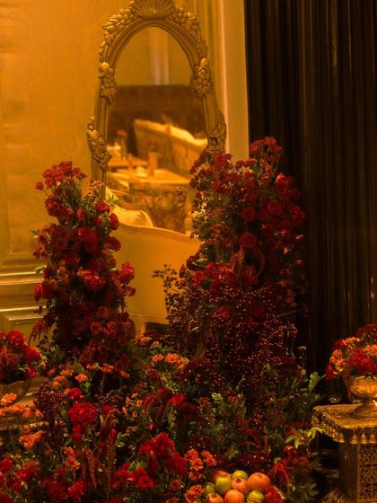 An ornate, gold framed mirror reflects the sea of red flowers, adding to the feeling of opulence and grandeur. Every corner of the venue was designed to be a picture perfect moment.